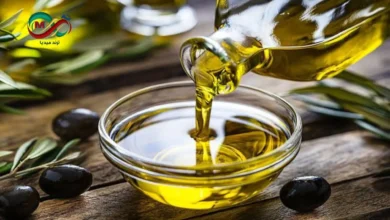 صورة توضح الفرق بين زيت الزيتون الأصلي والمغشوش في كوب اختبار شفاف.