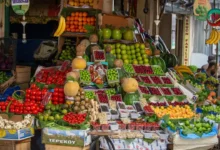 صورة توضيحية لمجموعة من الأطعمة المعززة للسعادة مثل الأسماك الدهنية، المكسرات، الفواكه والخضروات الملونة.