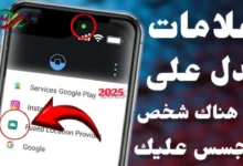 رسم توضيحي يظهر هاتفاً محمولاً مع إشارات تحذيرية تشير إلى المراقبة والاختراق.