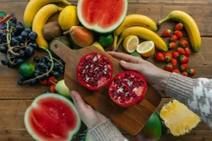 طبق يحتوي على تشكيلة فواكه حمراء طازجة تبرز فوائد الفواكه الحمراء للقلب مثل الرمان والفراولة والتوت.