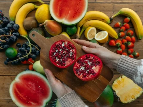 فوائد الفواكه الحمراء للقلب وضغط الدم – الدليل الكامل 1 طبق يحتوي على تشكيلة فواكه حمراء طازجة تبرز فوائد الفواكه الحمراء للقلب مثل الرمان والفراولة والتوت.
